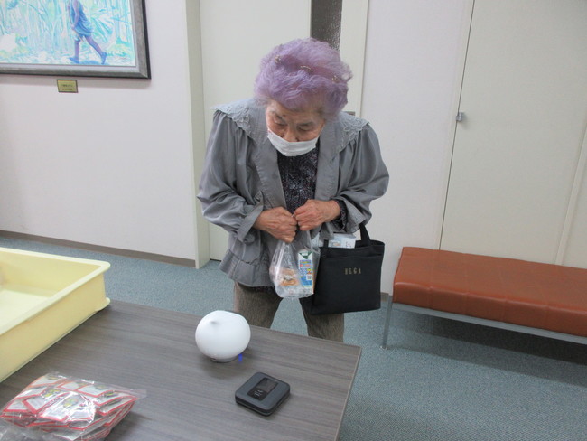 高齢者福祉施設で「Romi」と交流する高齢者